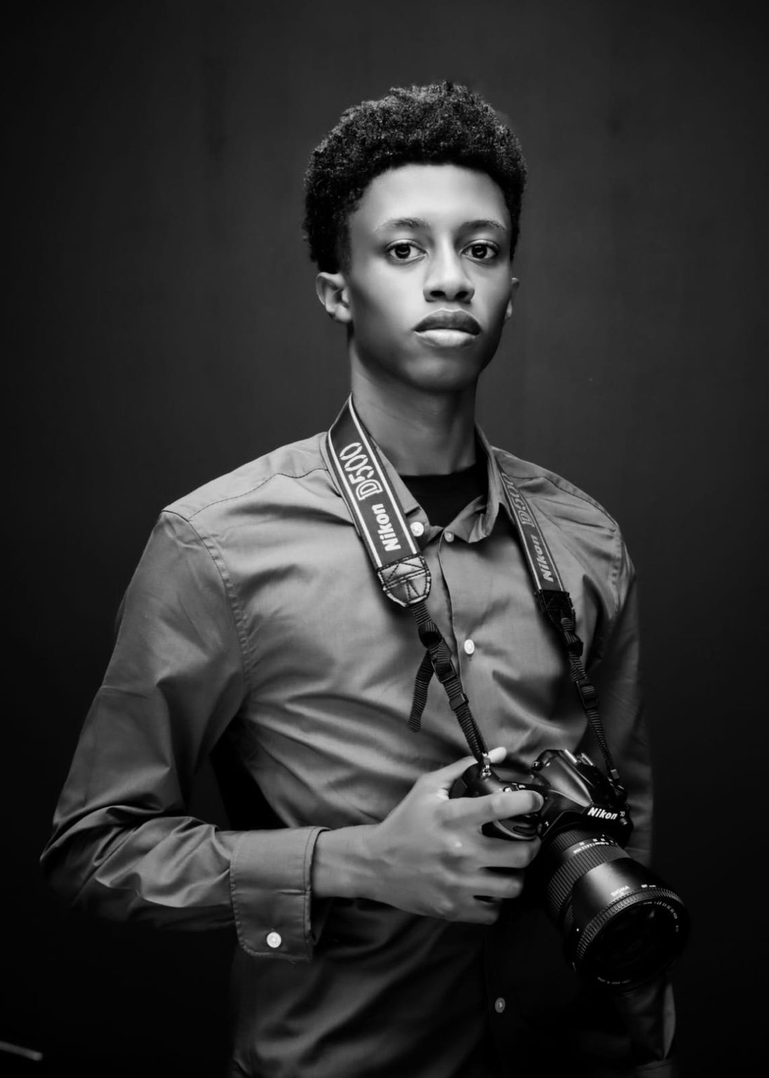 Black and white portrait of Seth holding a camera